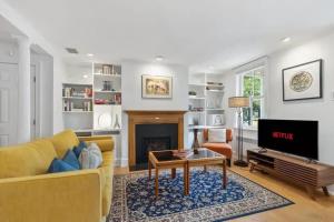 a living room with a yellow couch and a fireplace at Historic & Modern Capitol Hill 2-BR Row Home in Washington, D.C.