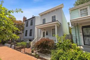 a white house with a fence in front of it at Historic & Modern Capitol Hill 2-BR Row Home in Washington, D.C.