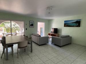 a living room with a table and chairs and a television at Les Villas Maristella, Villa Goria in Aregno