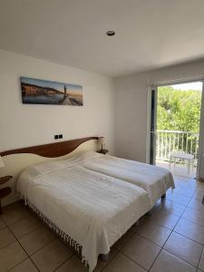 a bedroom with a bed and a large window at Les Villas Maristella, Villa Goria in Aregno