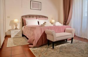 a bedroom with a pink bed and a chair at Il cretto bianco in Città di Castello