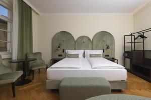 a bedroom with a large bed and a table at Stadt Hotel Citt&agrave; in Bolzano