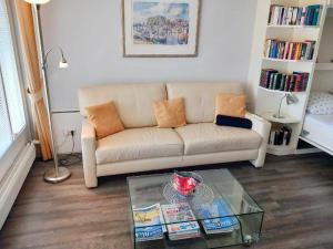 a living room with a couch and a glass table at PREMIUM APARTMENT 615 in Timmendorfer Strand +4 photos