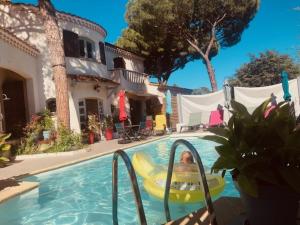 a person in a pool in a raft in the water at Maison d'hôtes naturiste Villa PaulAna in Cap d'Agde