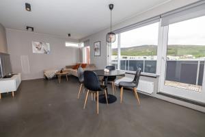 a living room with a table and chairs at Family apartment hosted by LL in Akureyri