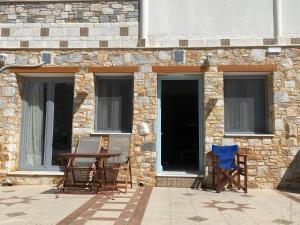 two chairs and a table in front of a building at Armonia Studios, Apartments & Villa in Mikri Vigla +20 photos