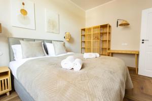 a bedroom with a large bed with towels on it at Apartamenty Rynek 12 in Tarnów