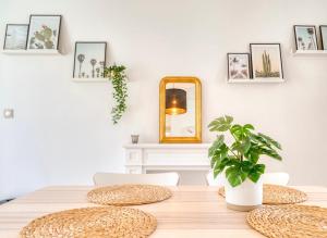 a dining room table with a mirror and a plant at Le petit coin de la rue Basse in Caen +2 photos