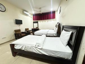 a bedroom with two beds and a clock on the wall at Millat Guest House F10-4 in Islamabad