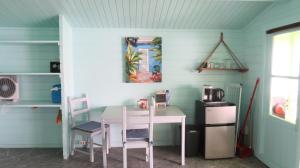 einen Tisch und Stühle in einer Küche mit einem Tisch und einer Mikrowelle in der Unterkunft Aquila apartments en studios in Willemstad