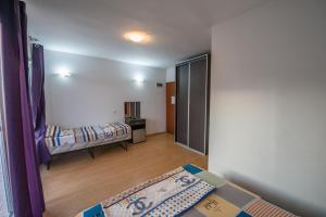 a living room with two beds and a door to a room at Rexha Apartments in Ulcinj