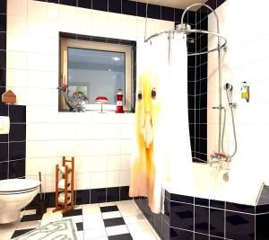 a bathroom with a shower with a yellow bird on the wall at Ferienwohnung Piesbach in Nalbach +21 photos