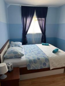 a bedroom with a bed with blue walls and a window at Apartments Villa Dalmatina in Vodice +73 photos