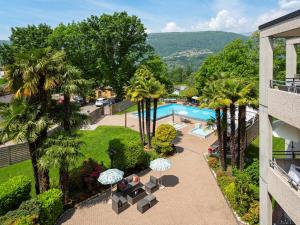an aerial view of a resort with a pool and palm trees at Resort Al Centro in Breganzona