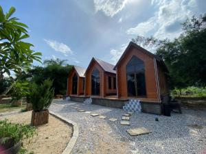 a house that is sitting on a gravel yard at Cool Pool Bungalow in Ban Phônmuang