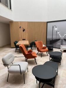 a waiting room with tables and chairs and a pier at Baltic Waves Resort Luksusowy apartamnet z basenem i parkingiem in Międzyzdroje