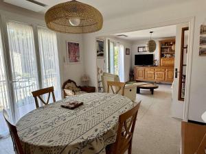 una sala da pranzo con tavolo e un soggiorno di Appartement familial climatisé avec terrasse, 2 chambres, à 8 km de la mer - Sorède - FR-1-225-737 a Sorède