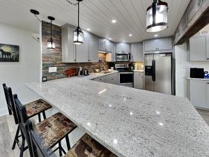 a kitchen with a large counter with chairs and appliances at Bear Feet in Oakland