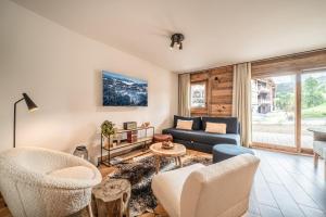 un salon avec un canapé et des chaises dans l'établissement Apartment Aldea Les Gets - by EMERALD STAY, aux Gets