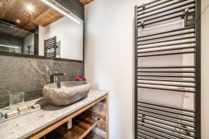 une salle de bain avec un lavabo et un miroir dans l'établissement Apartment Aldea Les Gets - by EMERALD STAY, aux Gets 24 autres photos