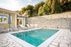 a swimming pool in a villa with a stone wall at villa Silda in Atsoupádhes