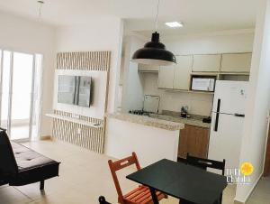 a kitchen and dining room with a table and a refrigerator at Espaçoso, bem equipado AR e piscina Climatizada in Ubatuba