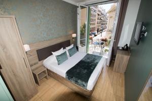 Postel nebo postele na pokoji v ubytování Hôtel Parisien