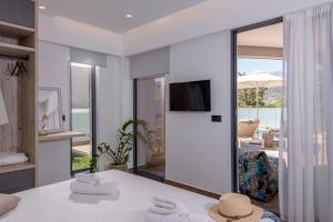 a white living room with a tv and a living room at Plakias Galaxy Villas in Plakias