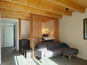 a living room with a couch and a bed at La Fruitière de Vérel, logements modulables neufs, calmes, entre lac et montagne, max 11 personnes in Rovagny