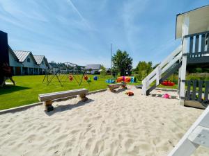 un parco giochi con panchine e attrezzature da gioco in un parco di Białe Domki Paula SPA Niechorze a Niechorze Altre 16 foto