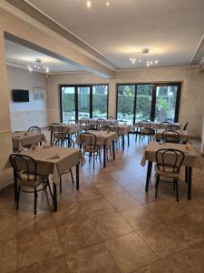 a dining room with tables and chairs and windows at Hotel Francesco in Padenghe sul Garda