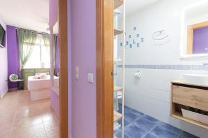 a bathroom with purple walls and a sink and a shower at Global Properties, Estudio para parejas en la playa del Puerto de Sagunto in Puerto de Sagunto +26 photos