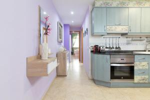 a kitchen with purple cabinets and a stove top oven at Global Properties, Estudio para parejas en la playa del Puerto de Sagunto in Puerto de Sagunto