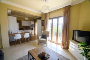 a living room with a large window and a kitchen at DENGE Homes in Lefkosa Turk