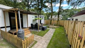 伊科斯特Chalet Kokomo - Gelegen In bosrijkgebied van Drenthe的后院设有房屋和围栏