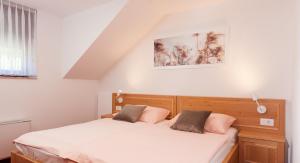 a bedroom with a bed with white sheets and pink pillows at Turistična kmetija Pri Marku in Žabnica