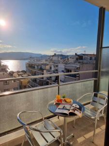 a table and chairs on a balcony with a view at Hotel Nefeli in Volos