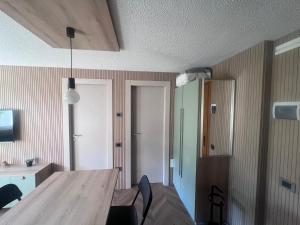 Un comedor con mesa y sillas de madera. en White Home Tonale, en Passo del Tonale