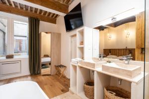 a bathroom with two sinks and a tv on the wall at Les Balcons de Guignol in Lyon +79 photos