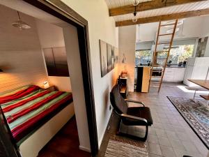 a bedroom with a bed and a chair and a kitchen at Villa Gauja - holiday home close to the sea and lake in Gauja