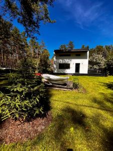 a house with a boat in front of a yard at Villa Gauja - holiday home close to the sea and lake in Gauja