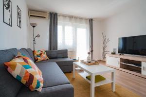 a living room with a couch and a tv at Apartman Sanda in Vukovar