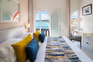 a bedroom with a bed with a view of the ocean at Hotel Suisse in Nice