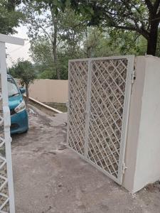 an open gate in a parking lot with a car at Abbasi guest house in Murree