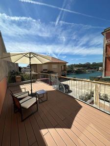 a wooden deck with a table and an umbrella at dvnest - Premium 1BR Apartment with River View! in Porto