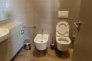 a bathroom with a toilet and a sink at dvnest - Premium 1BR Apartment with River View! in Porto +3 photos