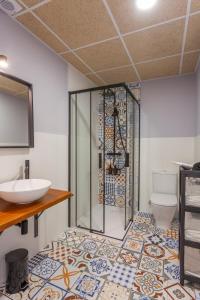 a bathroom with a shower and a sink and a toilet at Apartamentos Rurales TIN TURISMO in Santa Eulalia de Oscos +85 photos
