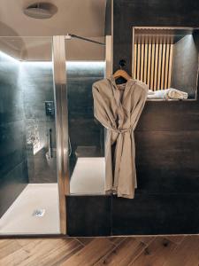 a shower stall with a robe on a shelf at Talking Stones in Dolceacqua