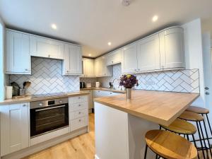 une cuisine avec des armoires blanches et un comptoir en bois dans l'établissement New~Breathtaking Bay Views~Chapel Street~Penzance, à Penzance