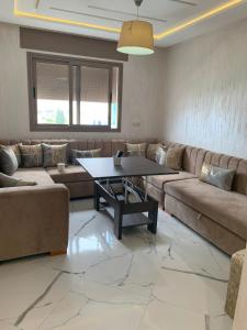un salon avec un canapé et une table dans l'établissement Apartamento perla del mar, à Martil